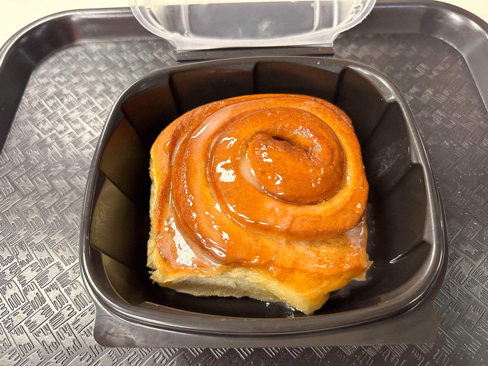 cinnamon roll in a black container
